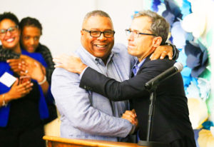 BGCB Nicholas President and CEO Robert Lewis, Jr. embraces Josh Kraft at the podium during the dedication ceremony